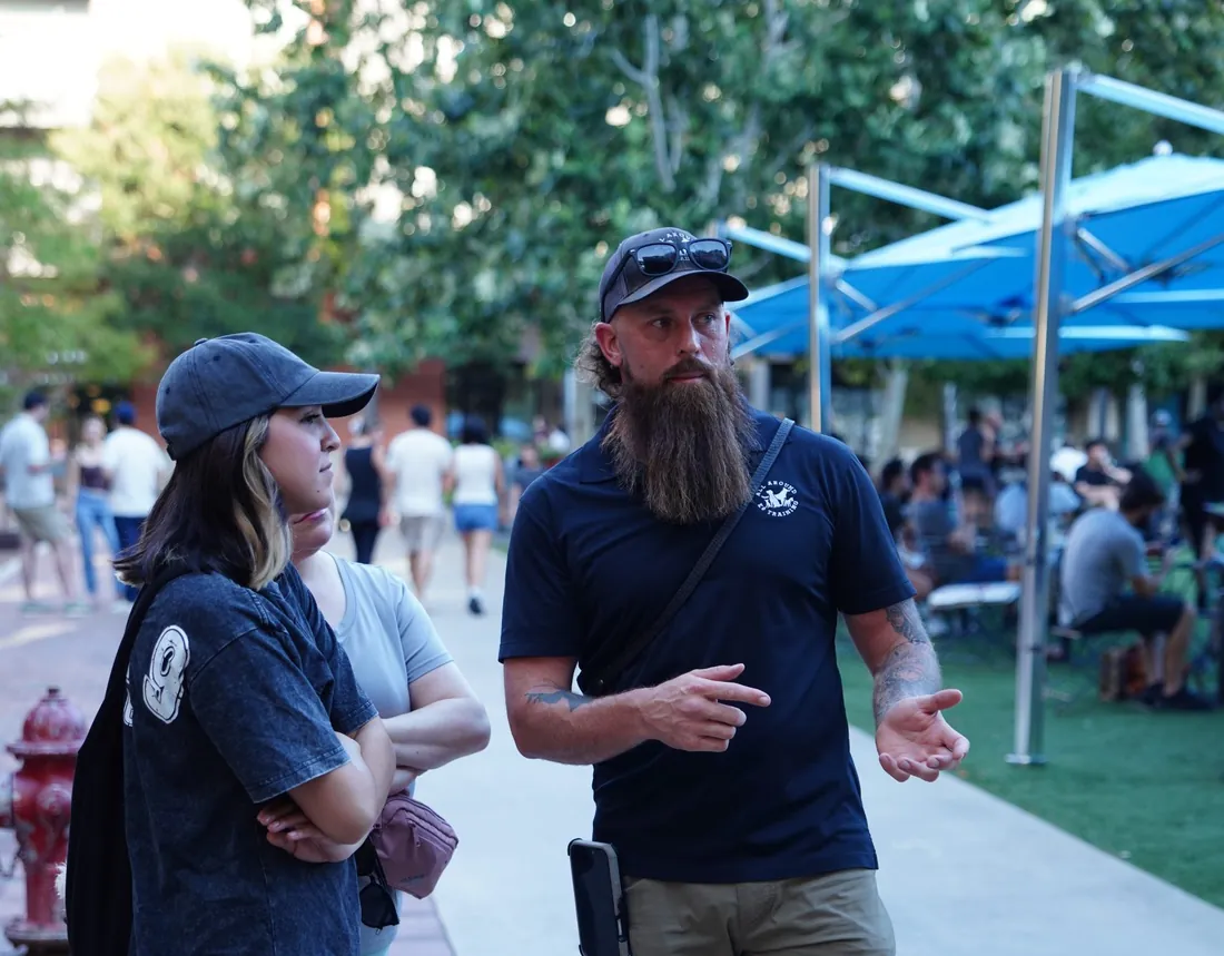 An All Around K9 Training trainer coaching dog owners during a real-world training session outdoors